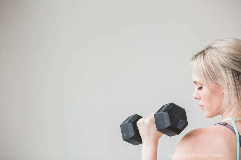 beautiful mature fit caucasian blond woman lifting dumbbell weight minimalism stock photo image